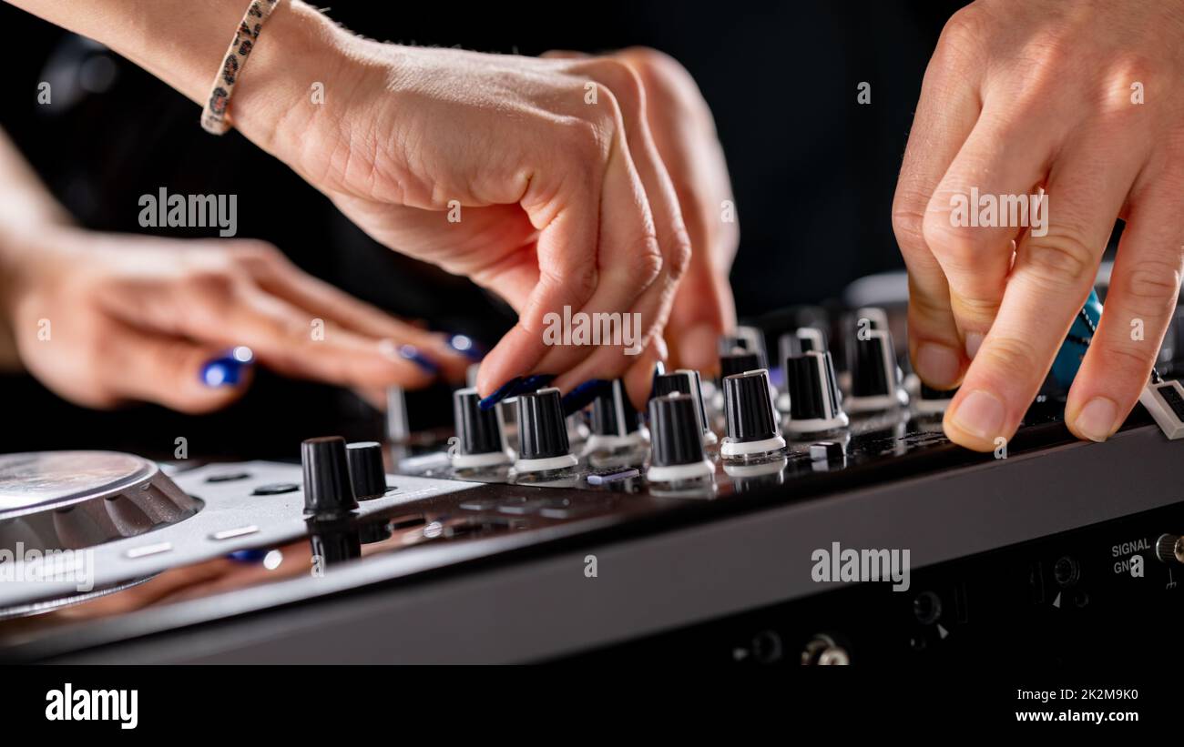 male and female DJ hands on a DJ consolle Stock Photo