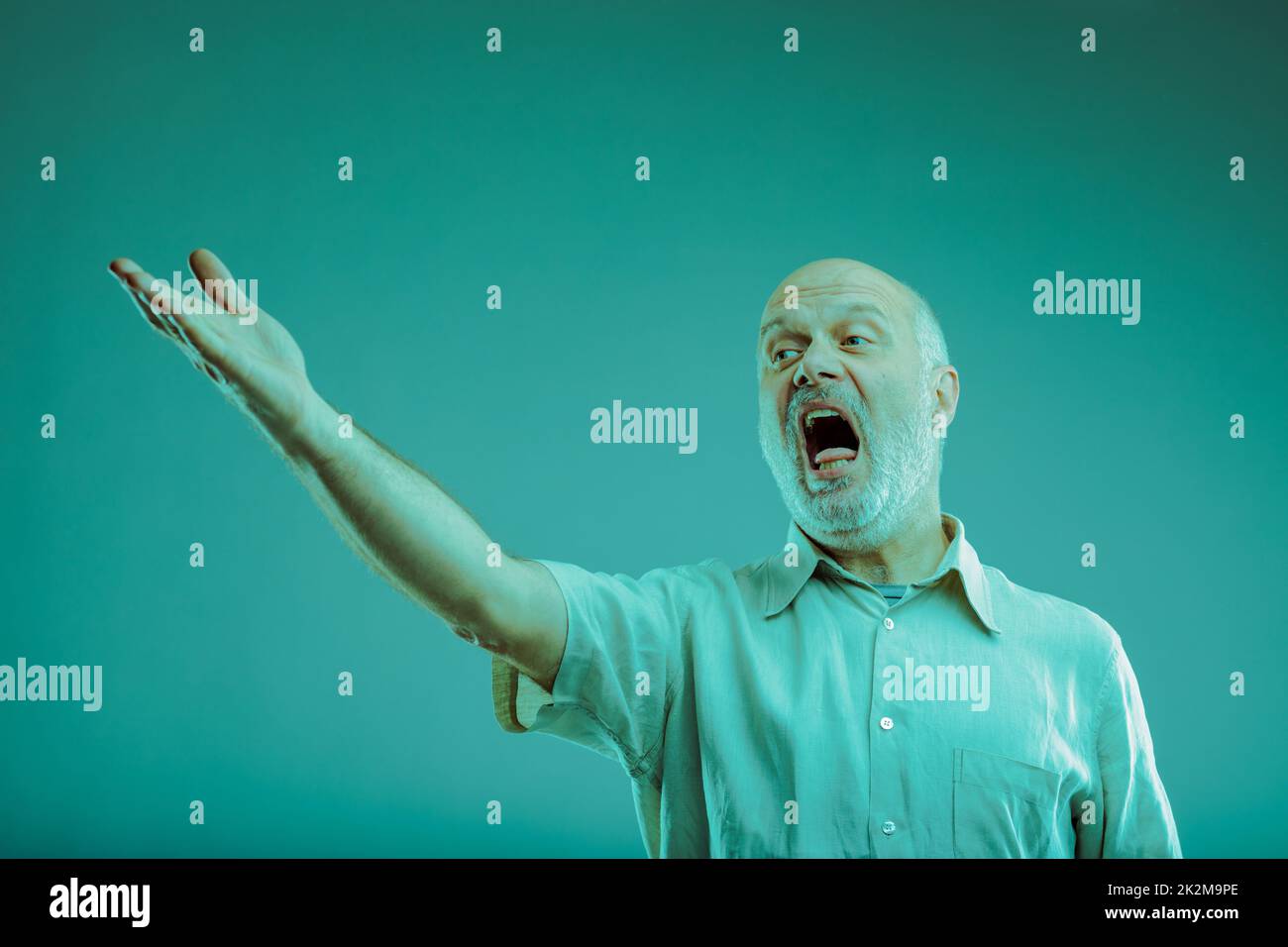 Senior man singing or screaming at someone gesturing with hand Stock Photo
