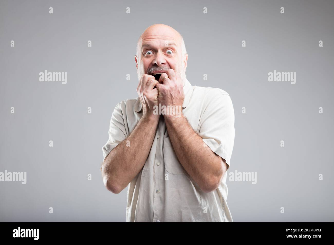 scared man biting his nails because of fear Stock Photo