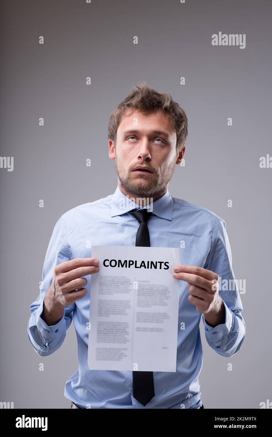 Man rolling his eyes over a Complaints notice Stock Photo Alamy