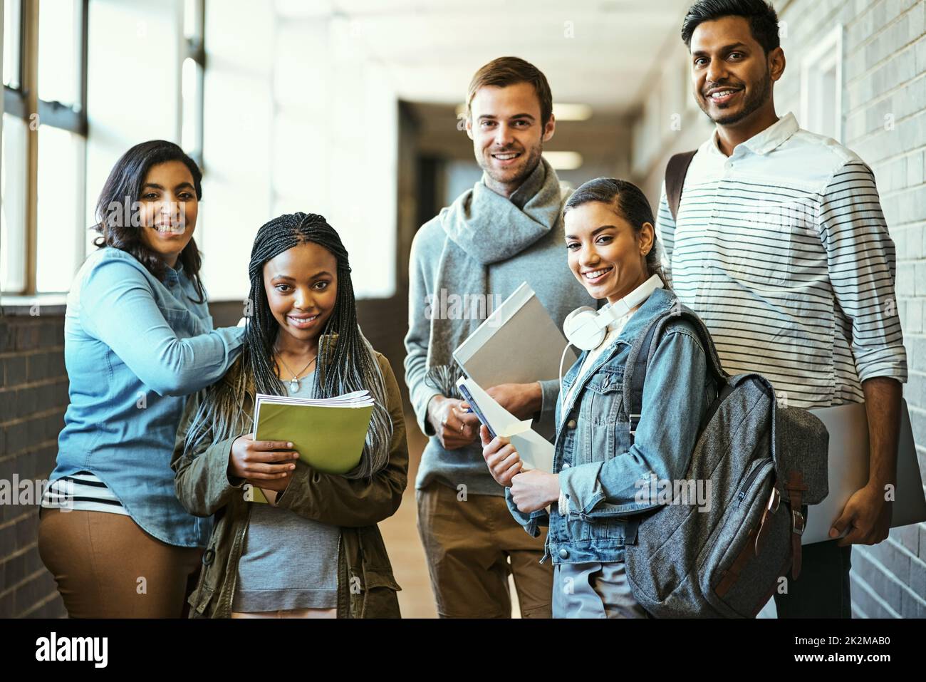 Campus clique. Cropped portrait of a group of university students standing in a campus corridor. Stock Photo