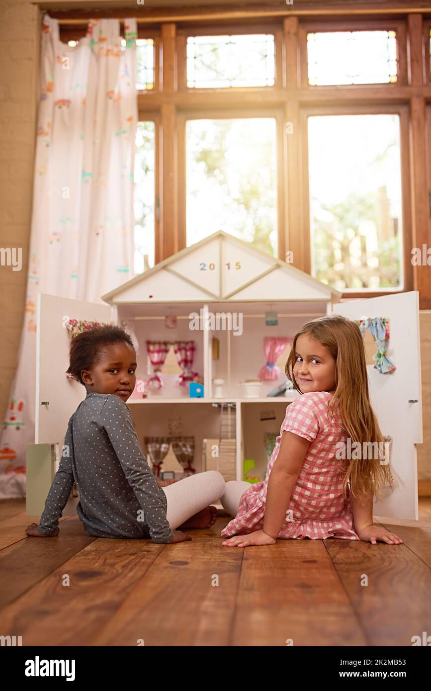 Theres nothing better than best friends playing together. Portrait of two friends playing together with a dollhouse. Stock Photo