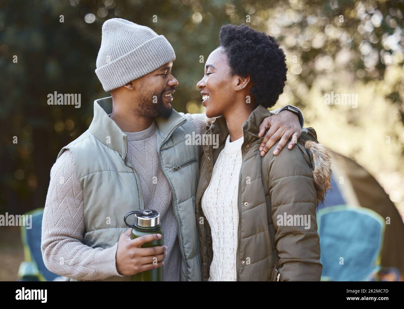 We should do this more often. Shot of a young couple being loving while camping together. Stock Photo