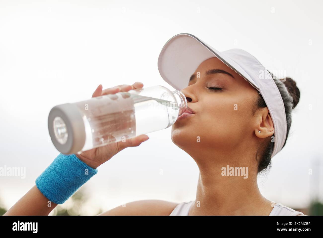 https://c8.alamy.com/comp/2K2MCBR/theres-no-better-way-to-quench-your-thirst-shot-of-a-beautiful-young-woman-drinking-a-bottle-of-water-while-out-playing-tennis-2K2MCBR.jpg