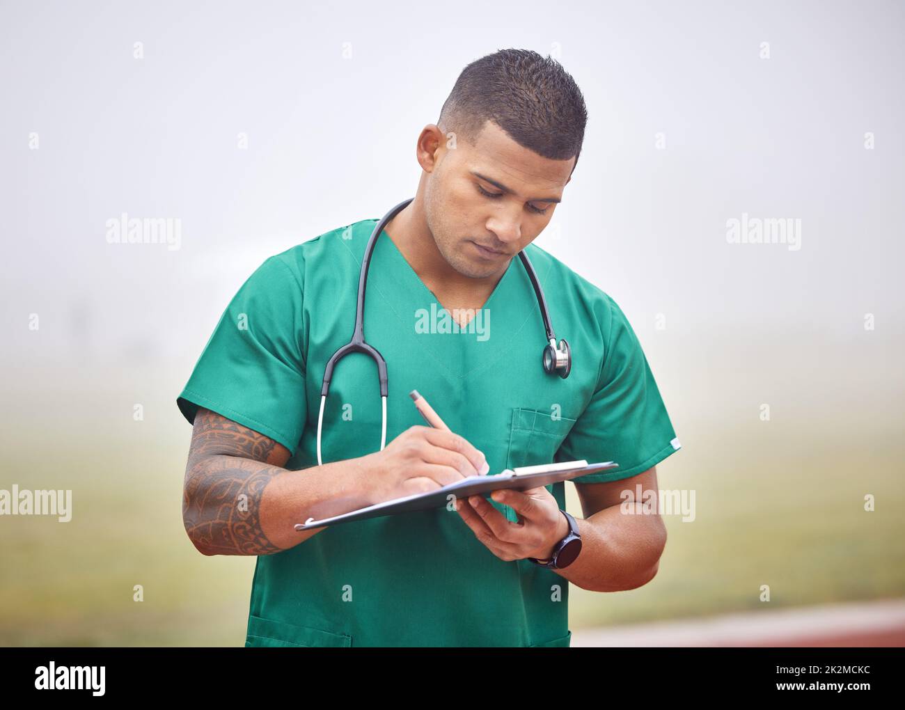 Paperwork is important. Cropped shot of a handsome young male paramedic