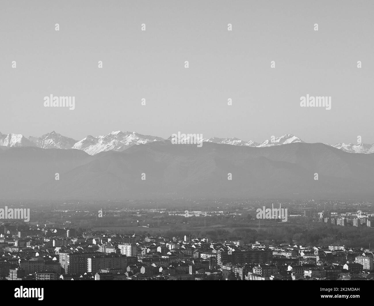 Aerial view of the city of Turin, Italy with Alps mountain range in the background in black and