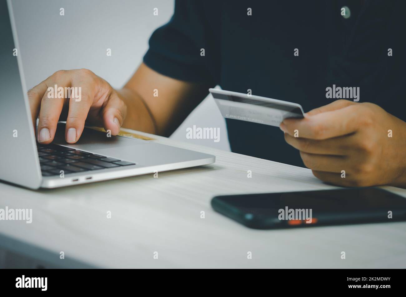male hands on computer keyboard doing financial and credit card transactions or online shopping on the Internet. Stock Photo