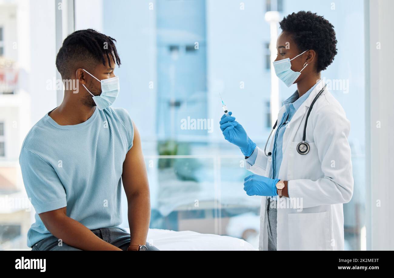That needle is huge doctor. Shot of a doctor about to inject the arm of a patient. Stock Photo