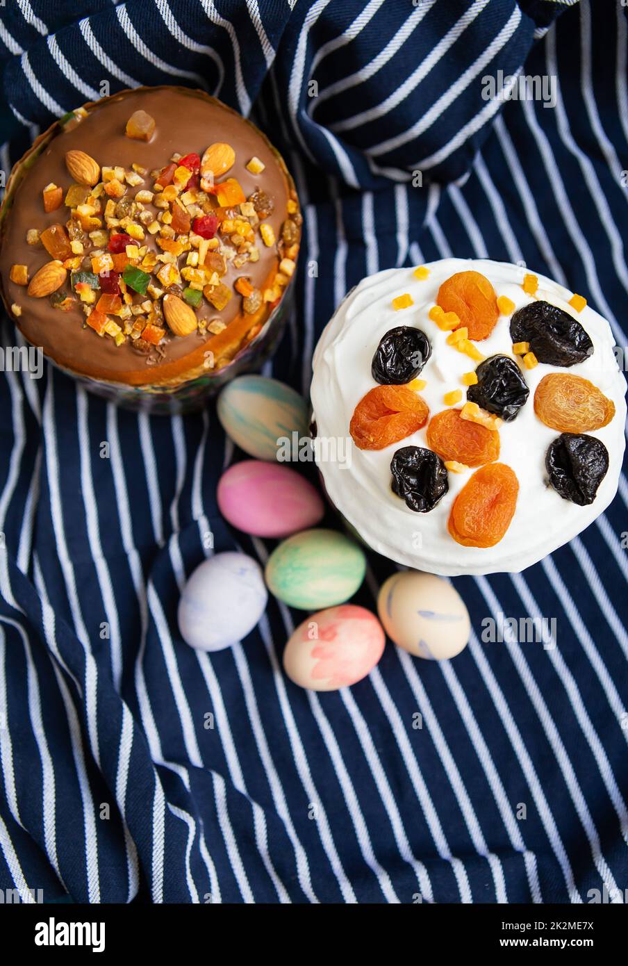 Easter eggs and Easter cakes lie on a striped blue apron. Easter religious holiday concept. Stock Photo