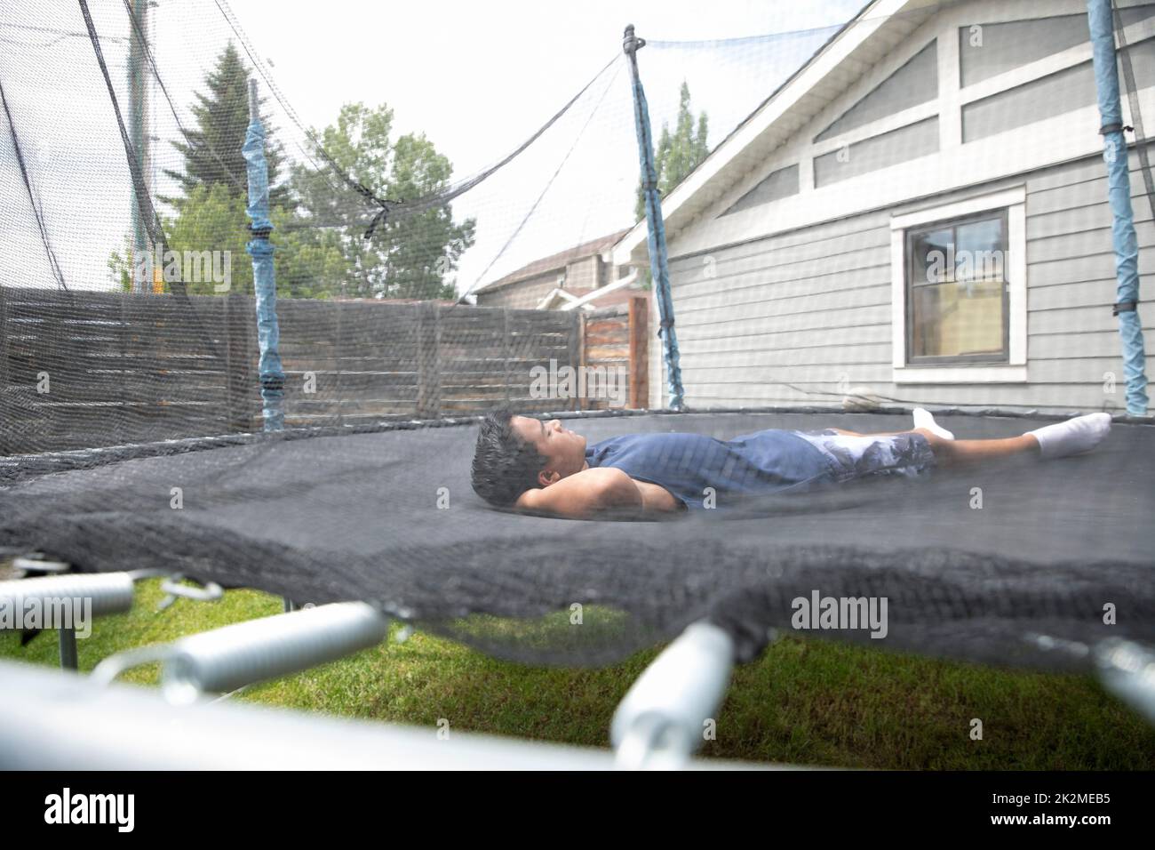 Boy sleeping on trampoline Stock Photo - Alamy