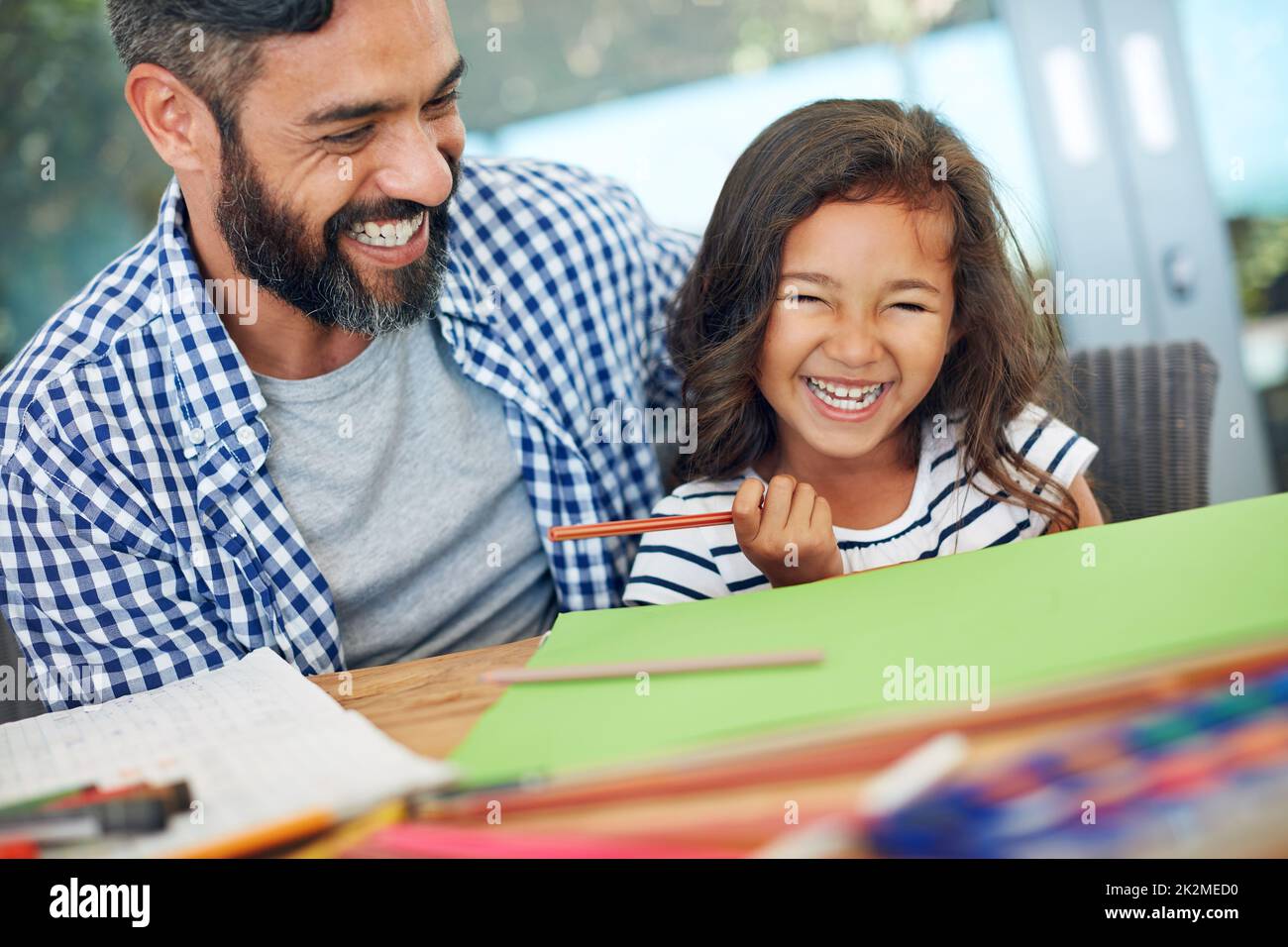 Fun-filled creative times. Cropped shot of a father and daughter colouring in together at home. Stock Photo