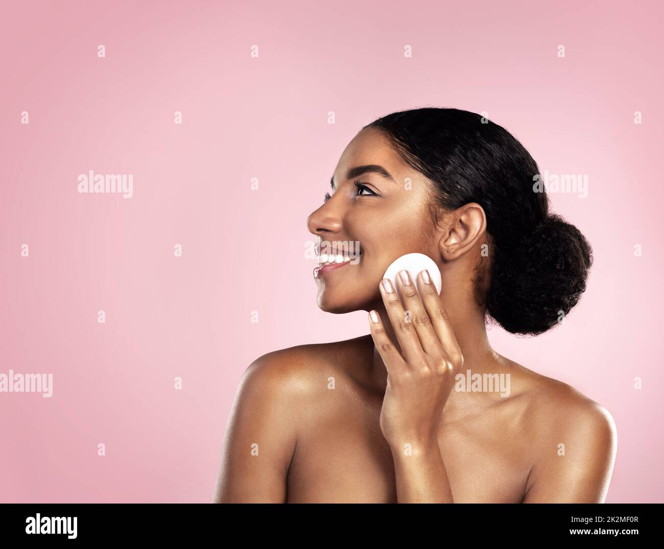 I only use the best cleansers. Studio shot of a beautiful young woman cleaning her face with cotton wool. Stock Photo