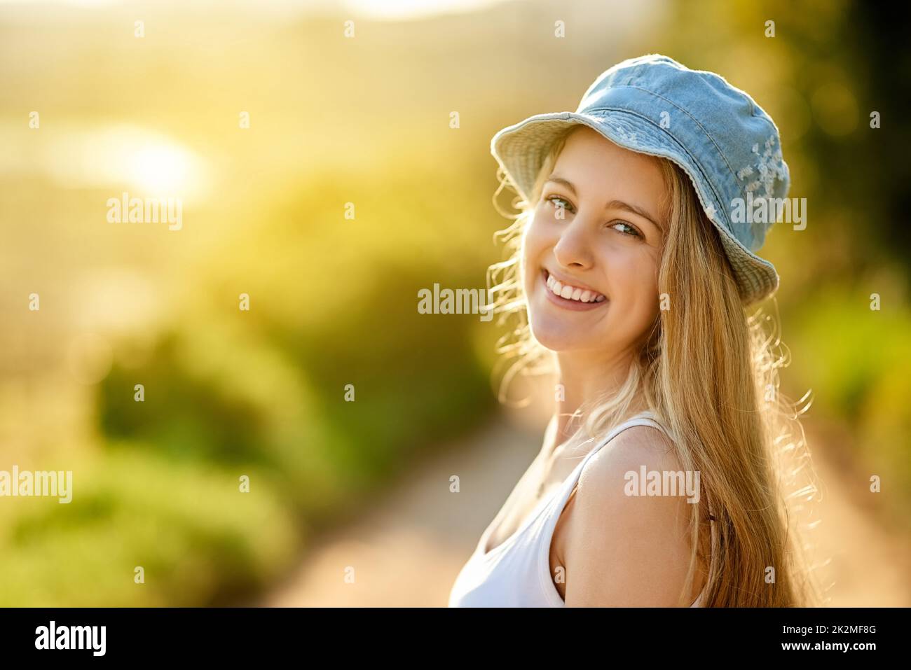 I love being outside. Shot of a young woman on a tree stump out in the countryside. Stock Photo