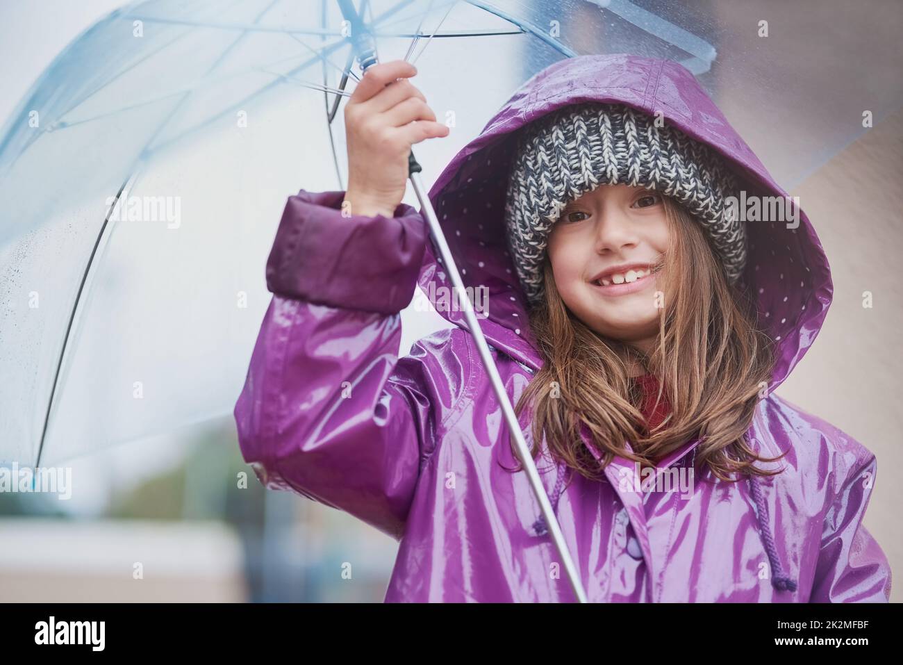 The cold never bothered me anyway. Portrait of a little girl standing under an umbrella outside. Stock Photo