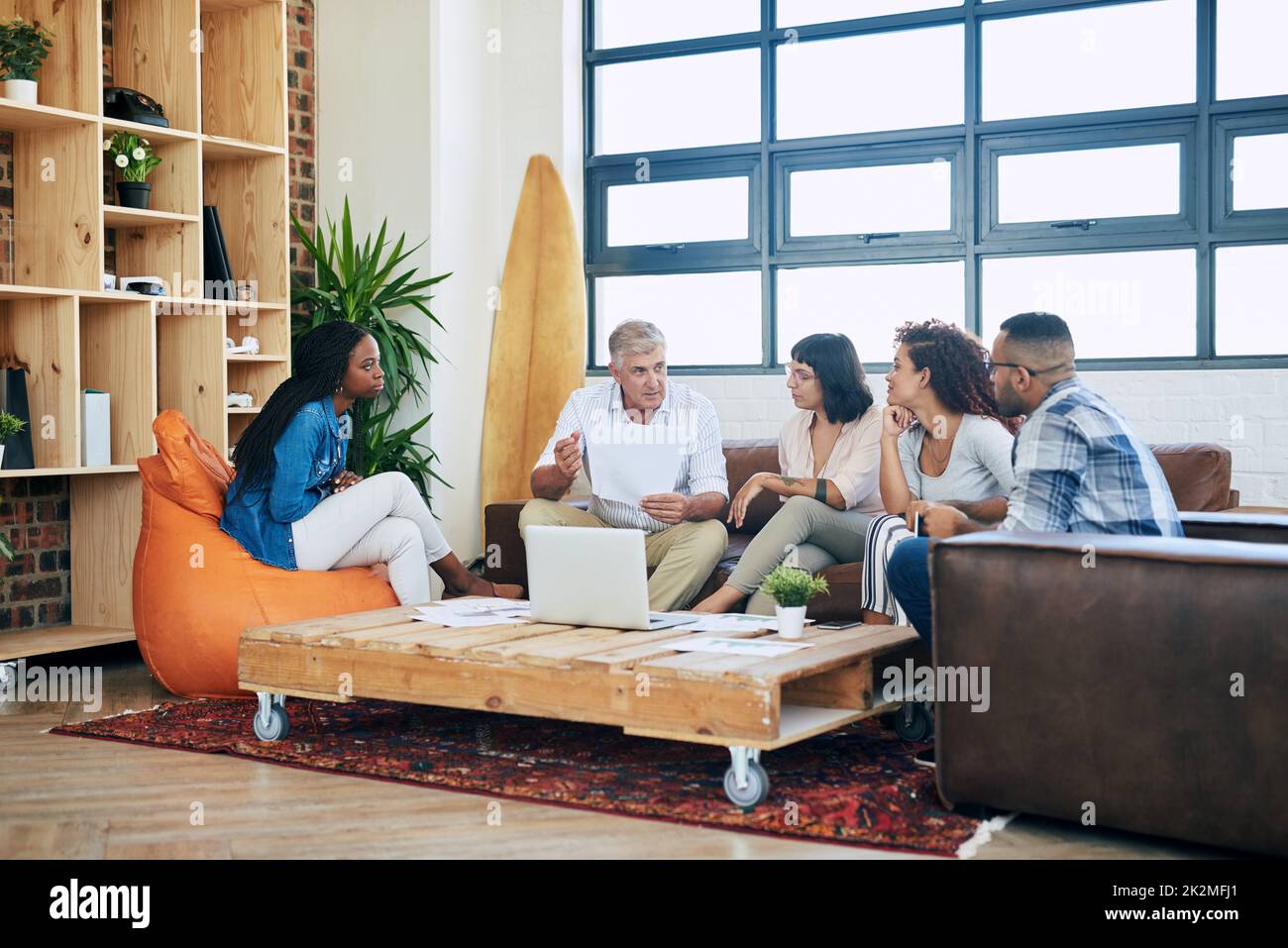 Using his position of power wisely. Shot of a group of colleagues collaborating in a modern office. Stock Photo