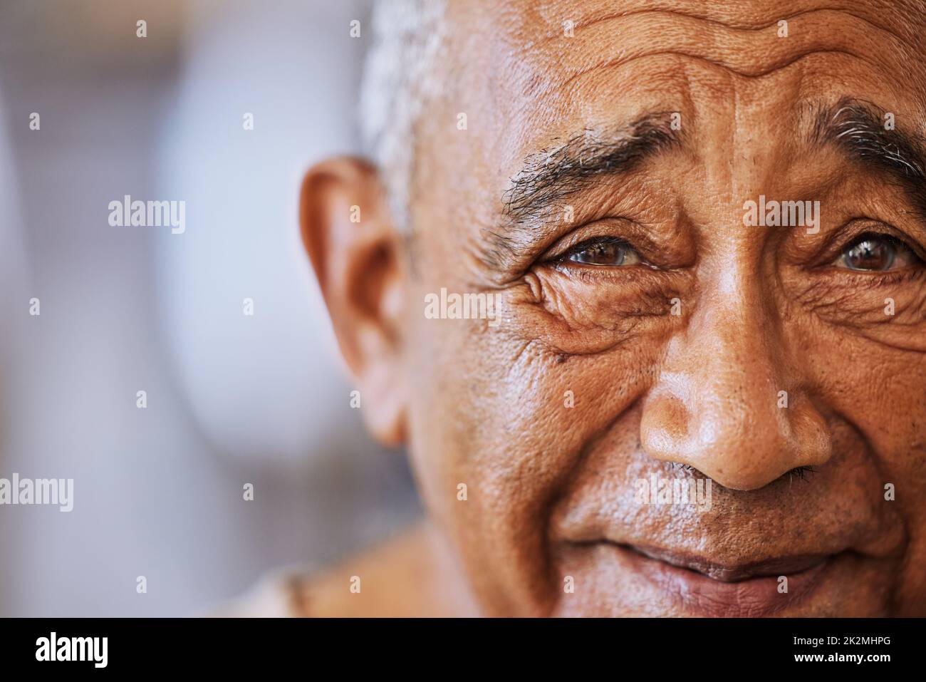 Portrait of a happy, kind black senior mans face with wrinkles, smile and friendly in a retirement home. Happiness, joy and positive elderly black man Stock Photo