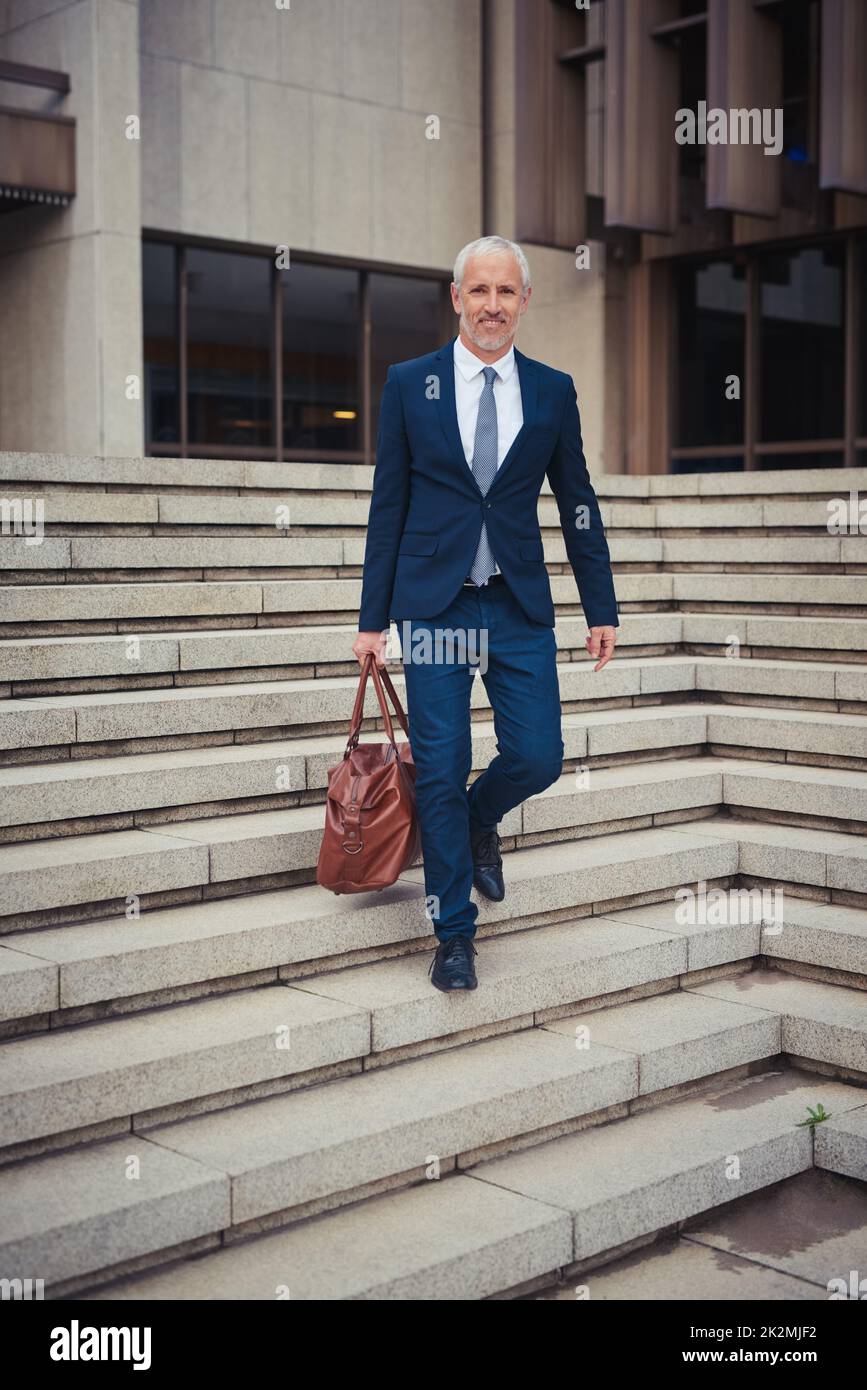 Going home after a productive day. Portrait of a confident businessman leaving his office building after a day at work. Stock Photo