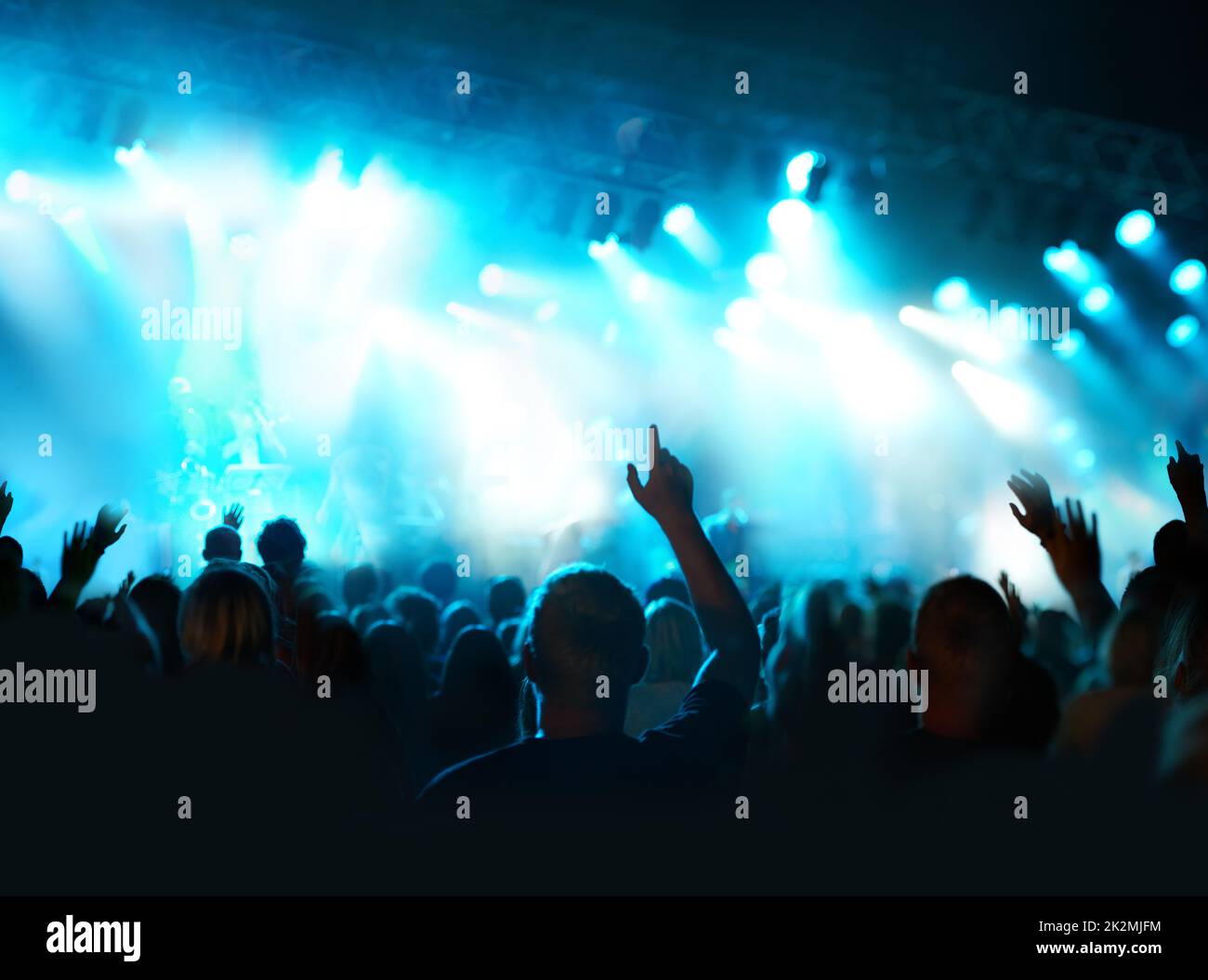 Music in the night under the lights. Shot of a fans watching a live concert. Stock Photo