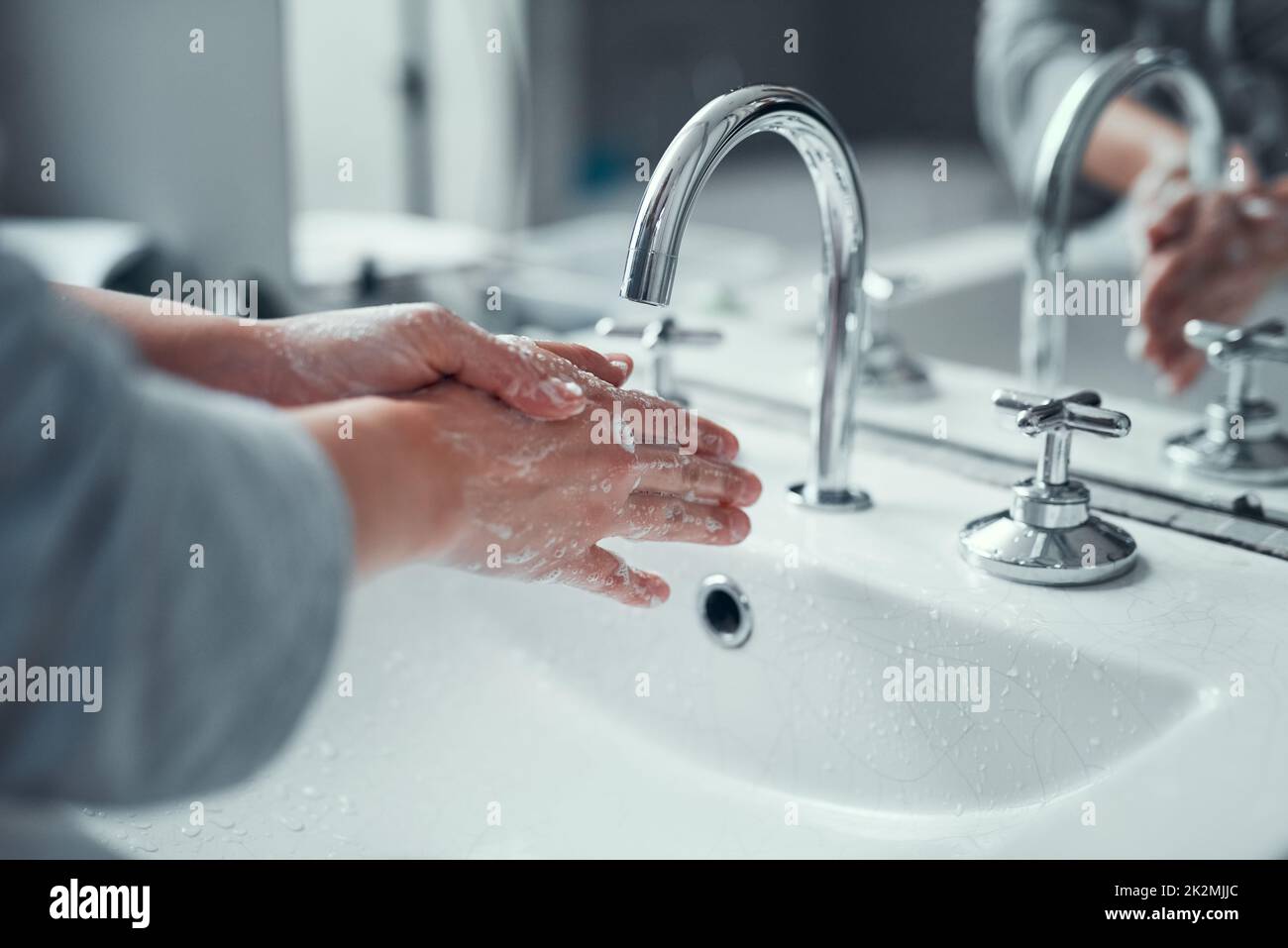 Its vital to practice good personal hygiene. Closeup shot of an unrecognizable woman washing her hands in the bathroom at home. Stock Photo