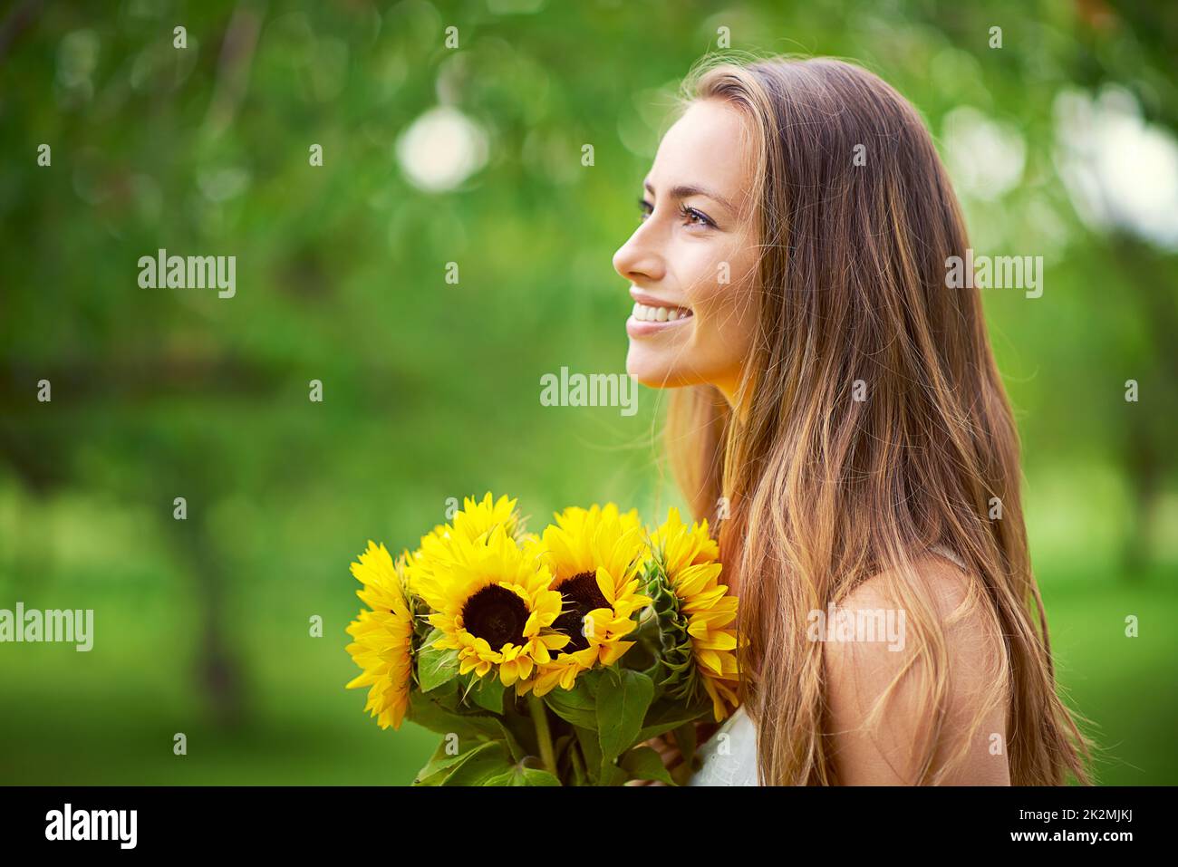 Be like a sunflower, turn your face to the sun. Shot of a young woman