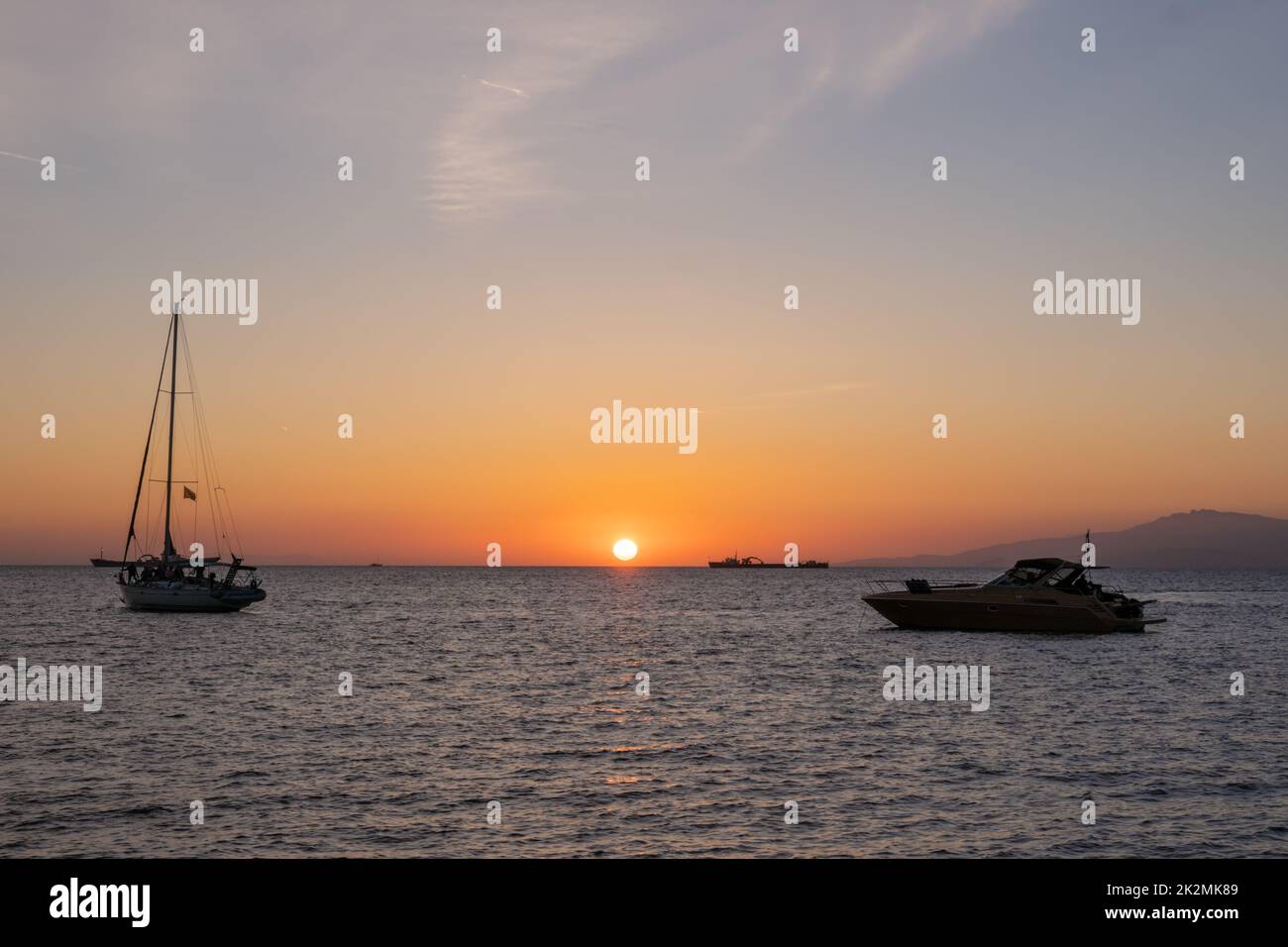 Sunset in Mykonos, Greece and yachts in the harbor Stock Photo