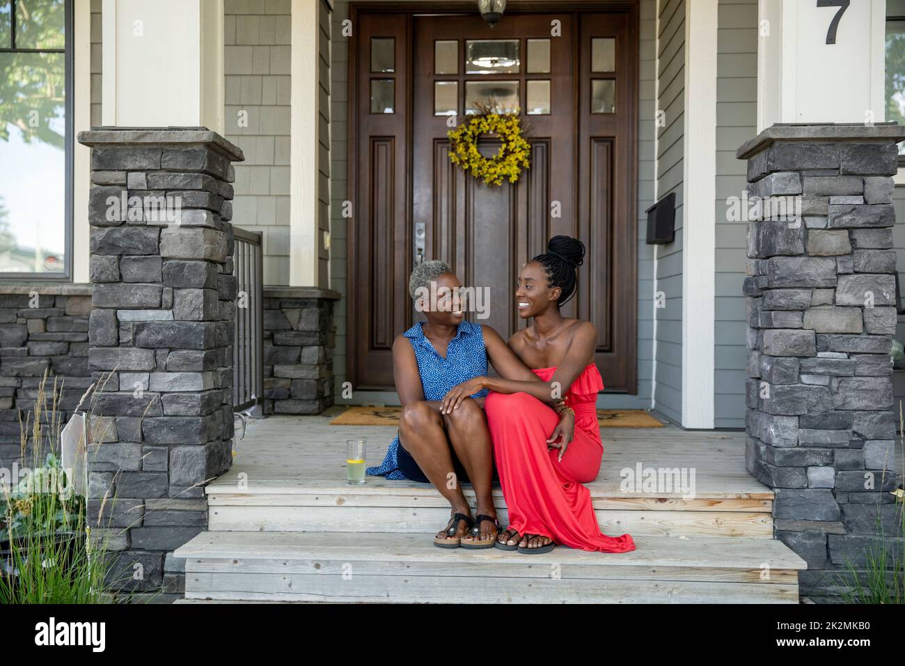Portrait of mother and daughter sitting on front porch steps Stock Photo Alamy