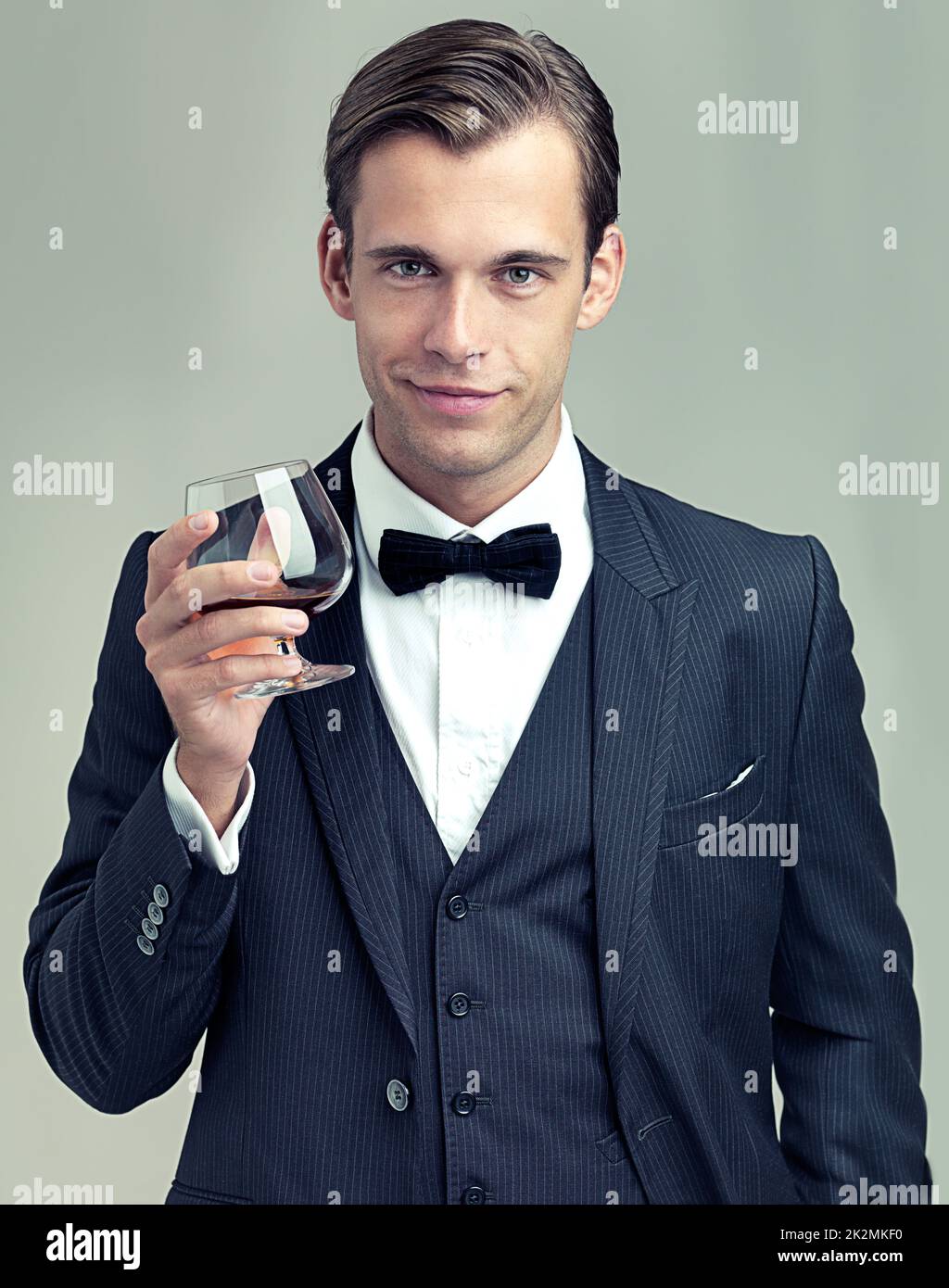 Heres to frivolity. A portrait of a dapper young man with a glass of