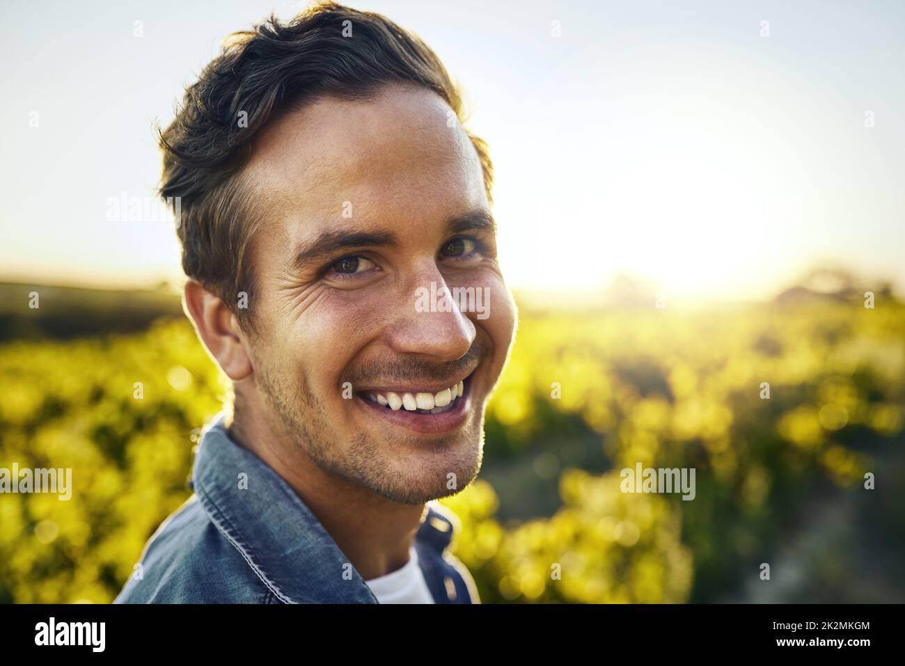 Its the season for some pickin. Portrait of a happy young man working on a farm. Stock Photo