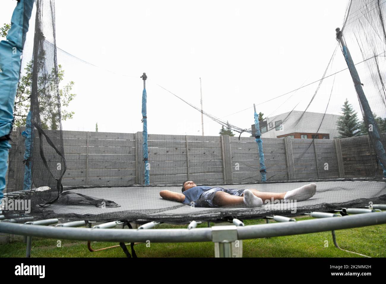 Boy sleeping on trampoline Stock Photo - Alamy