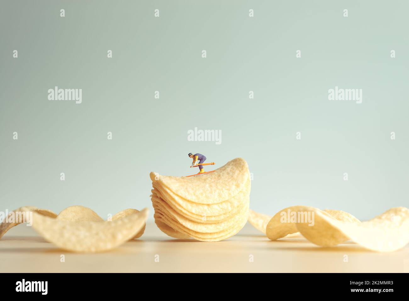 Miniature skier skiing down potatoe chips Stock Photo