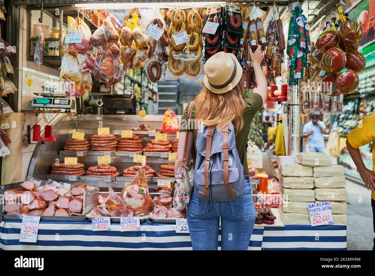 So many choices. Rearview shot of an unrecognizable woman standing next to a market stall while browsing through the items on display. Stock Photo