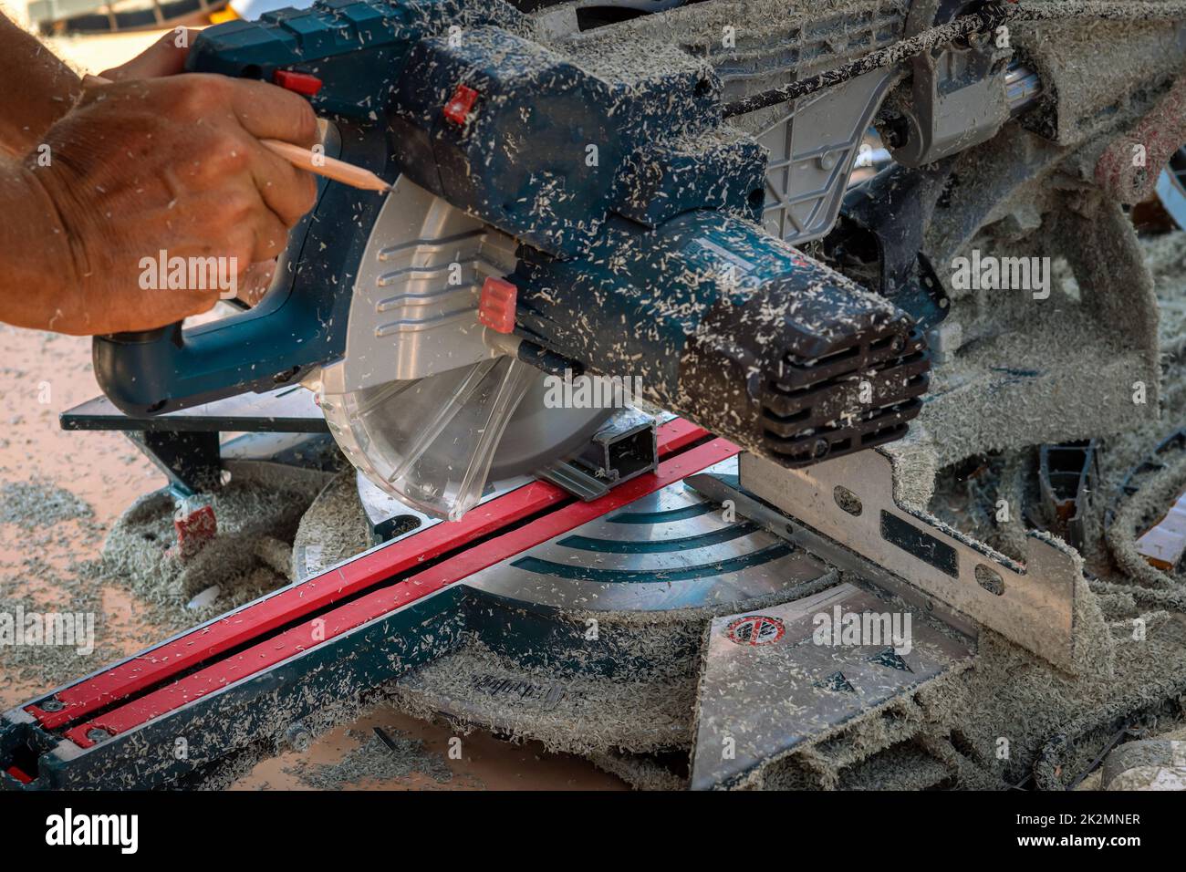 Miter saw. Cutting of PVC profile for siding. Sawdust. Selective focus Stock Photo