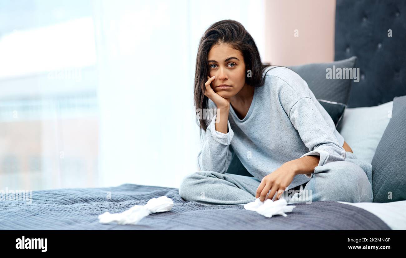 Nothing challenges your patience like a pandemic. Shot of a young woman recovering from an illness in bed at home. Stock Photo