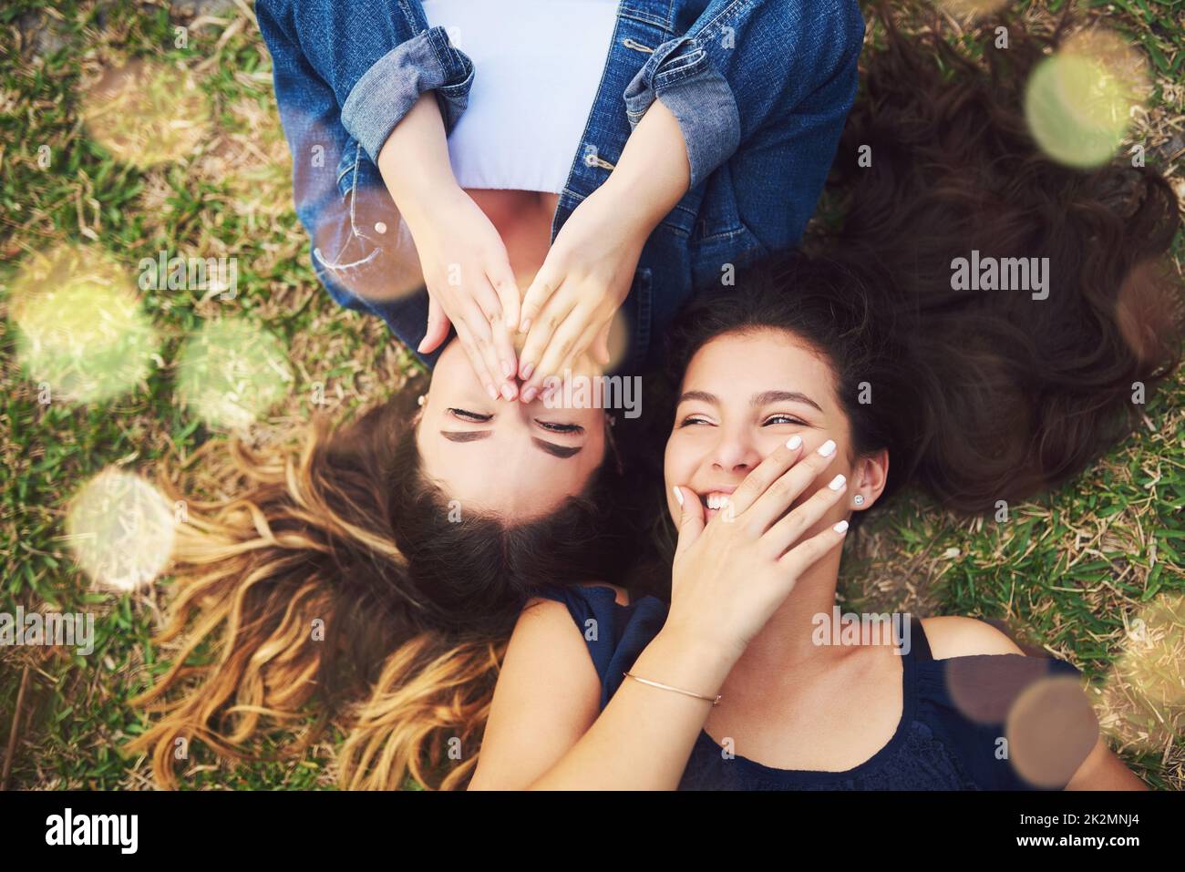 Her jokes are the funniest. High angle shot of two female best friends spending the day in a public park. Stock Photo