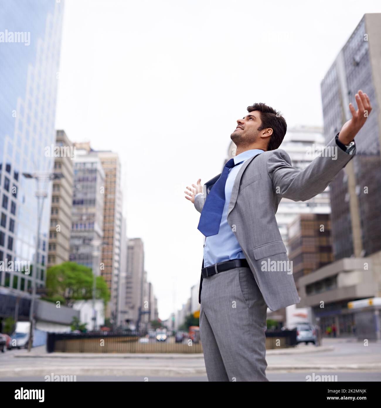 A love for the city. A contented young businessman standing in the city with his eyes closed and his arms raised. Stock Photo