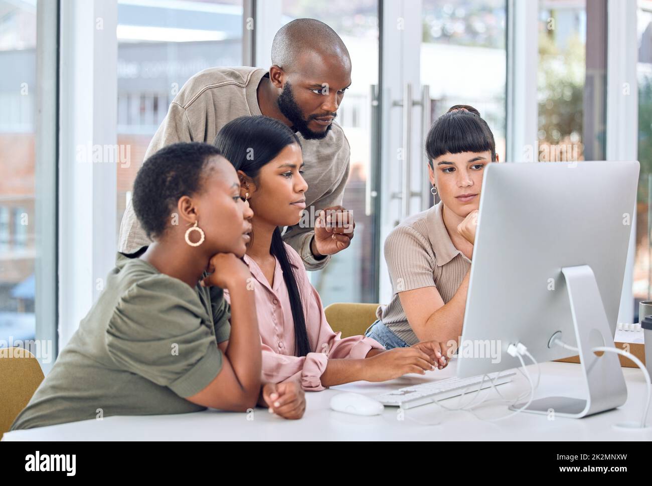 Everyone is striving towards one unified goal. Shot of a group of businesspeople discussing something on a desktop. Stock Photo