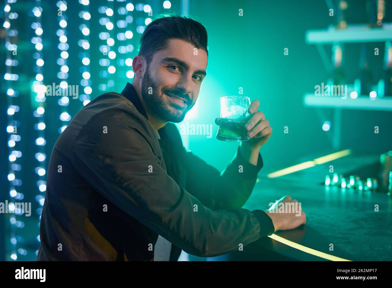 Welcoming the weekend. Portrait of a relaxed young man drinking alone in a bar. Stock Photo