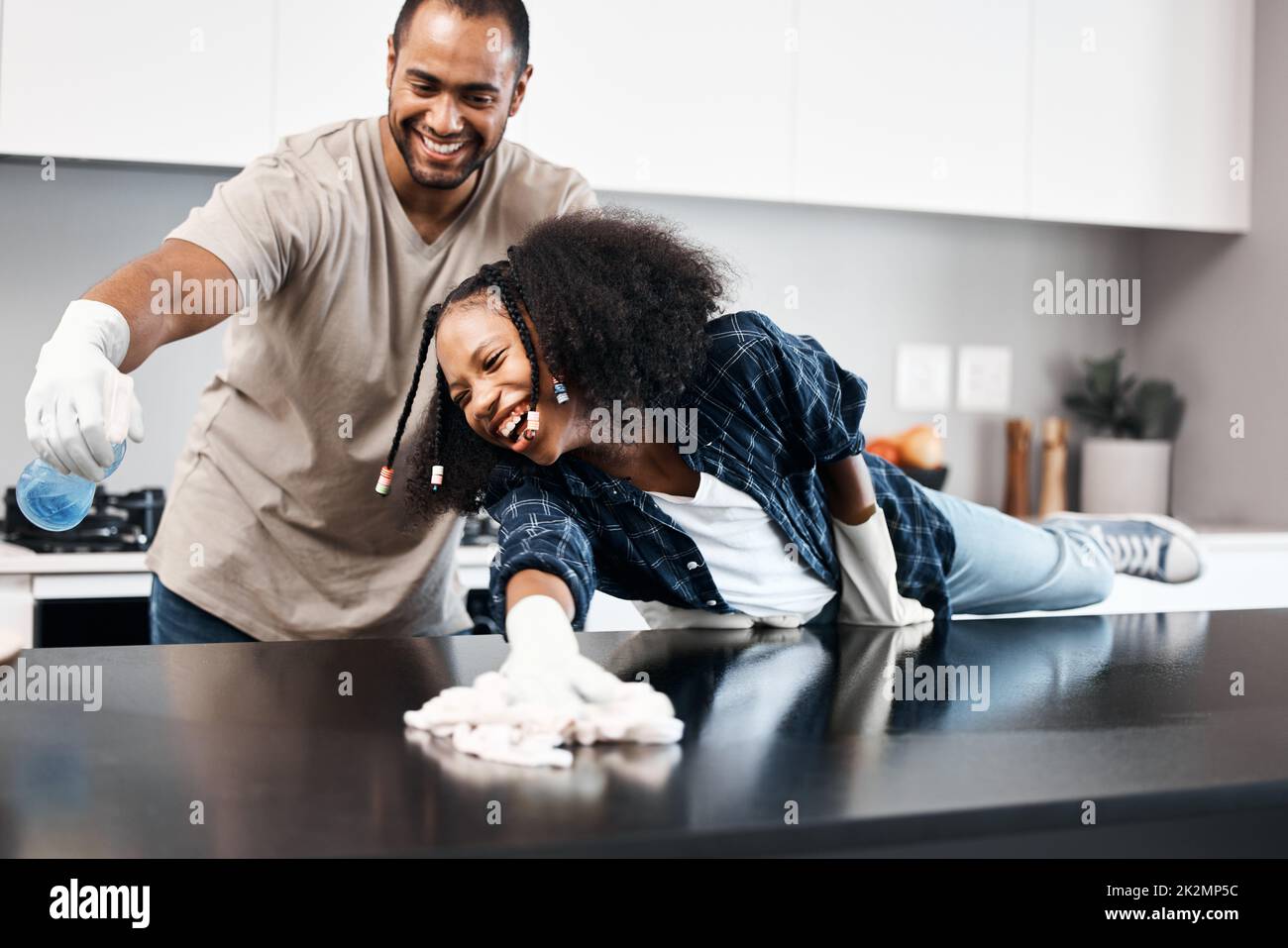 https://c8.alamy.com/comp/2K2MP5C/the-dirt-busting-father-daughter-duo-shot-of-a-young-girl-helping-her-father-clean-the-kitchen-counter-at-home-2K2MP5C.jpg