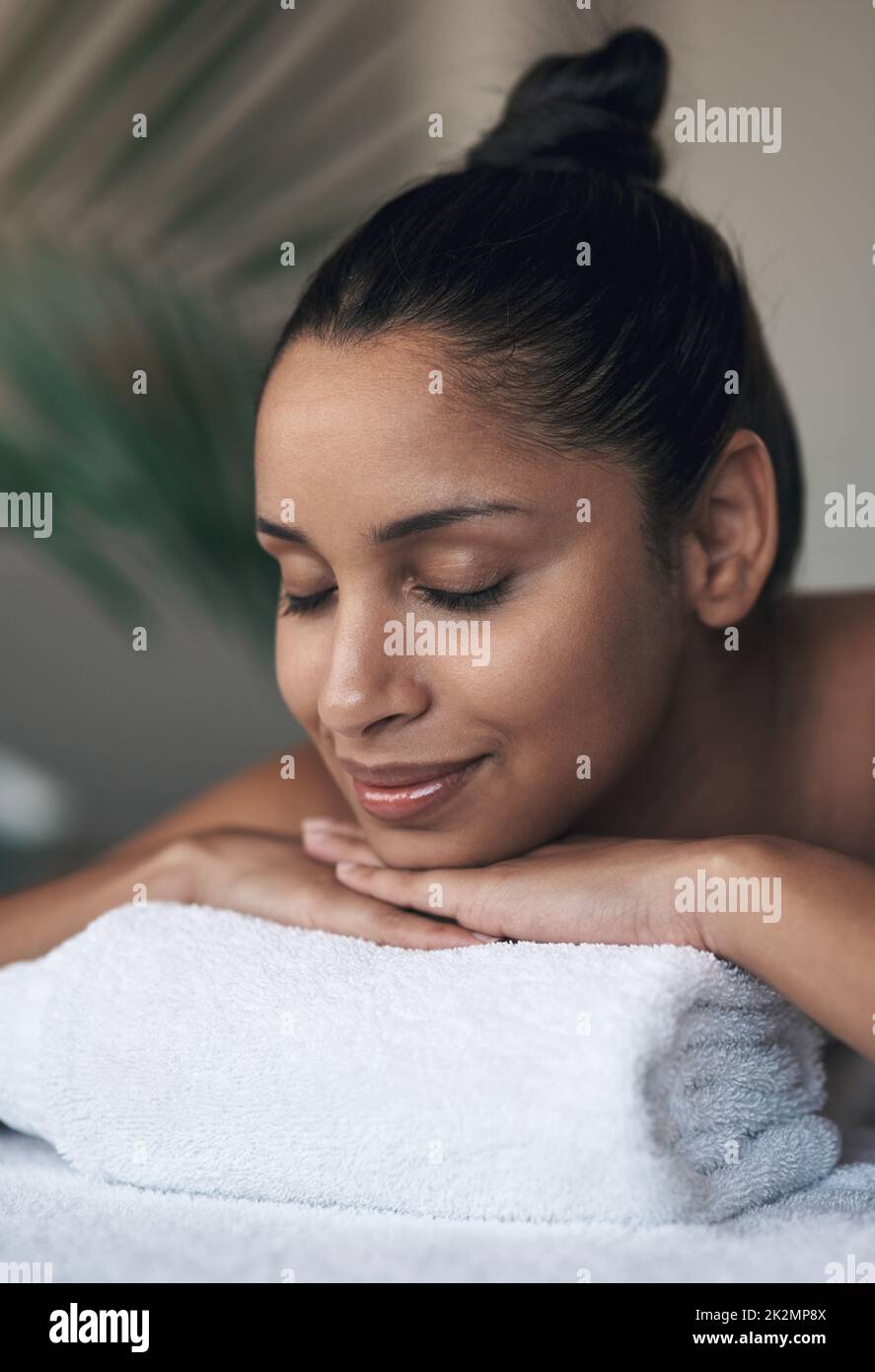 Rest well and your energy will be restored. Shot of a young woman lying on a massage bed at a spa. Stock Photo