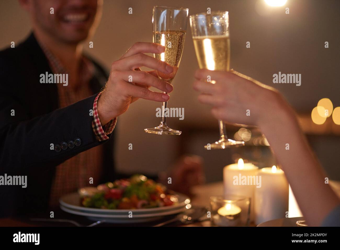 Love should be celebrated every day. Cropped shot of a young couple making a toast. Stock Photo