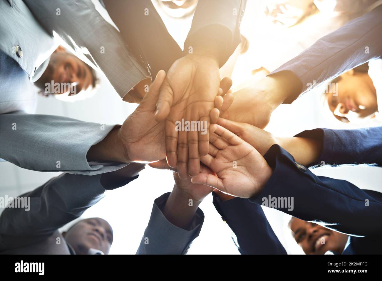 Teamwork on three. Low angle shot of a diverse group of businesspeople joining their hands together. Stock Photo