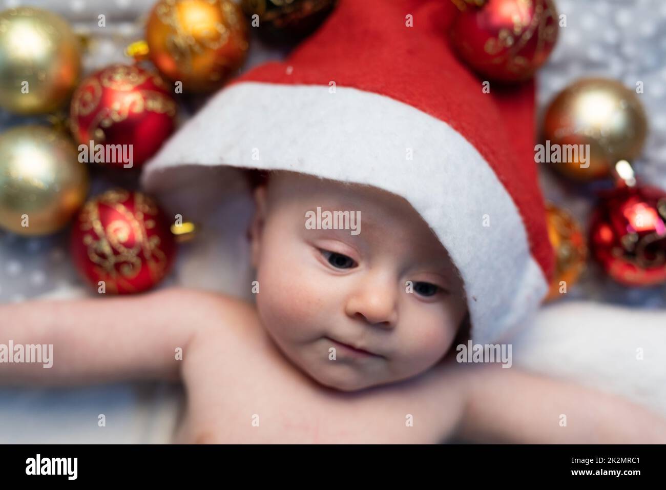 Cute tiny baby wearing a Christmas Santa hat Stock Photo