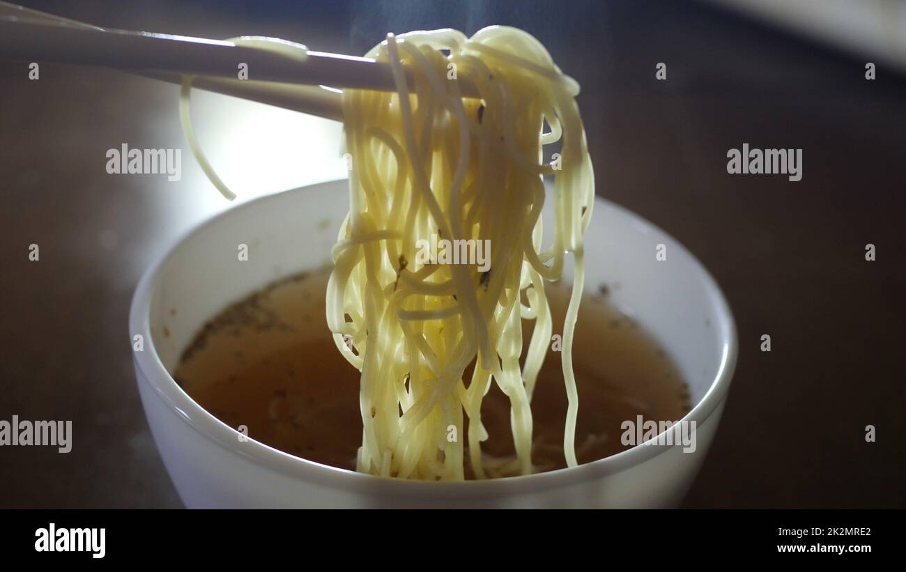 Close up of instant noodles yellow ramen and  Chinese chopsticks Stock Photo