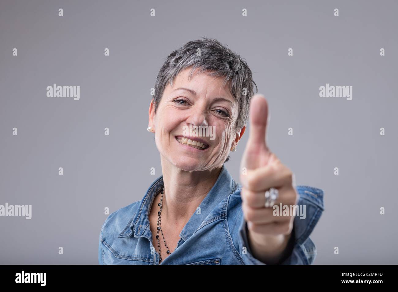 Happy enthusiastic lady giving a thumbs up Stock Photo