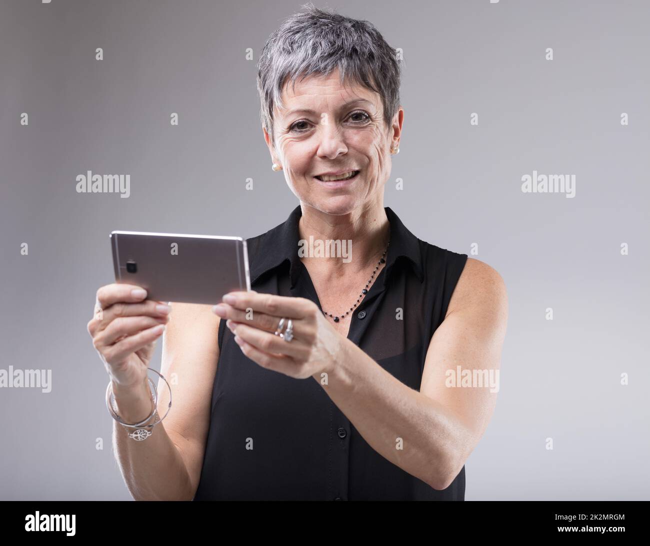 Older woman holding a mobile phone Stock Photo - Alamy