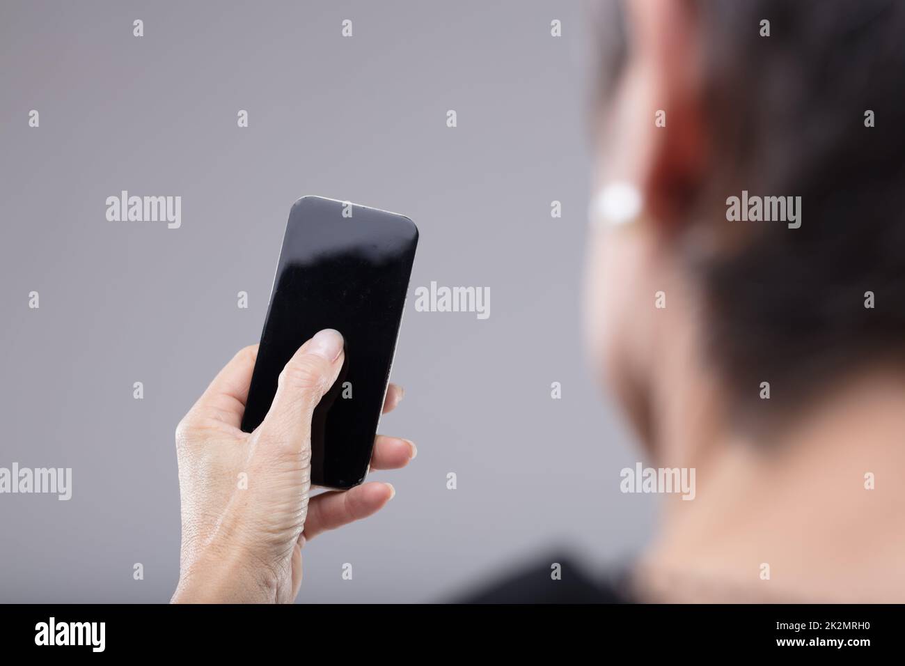 Woman holding a blank mobile phone in her hand Stock Photo