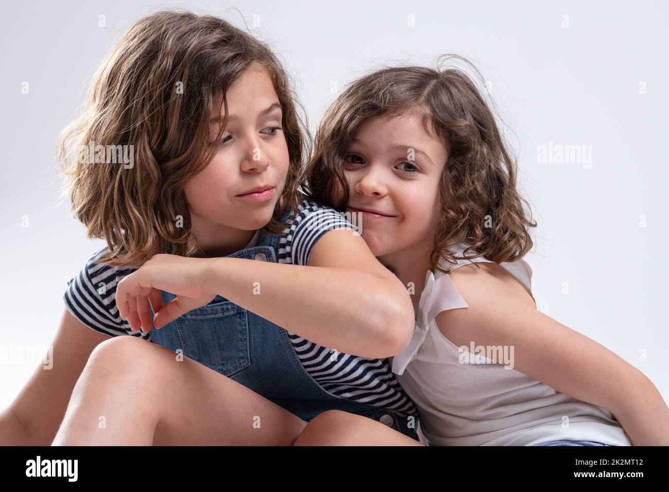 Two attractive young sisters cuddling together Stock Photo