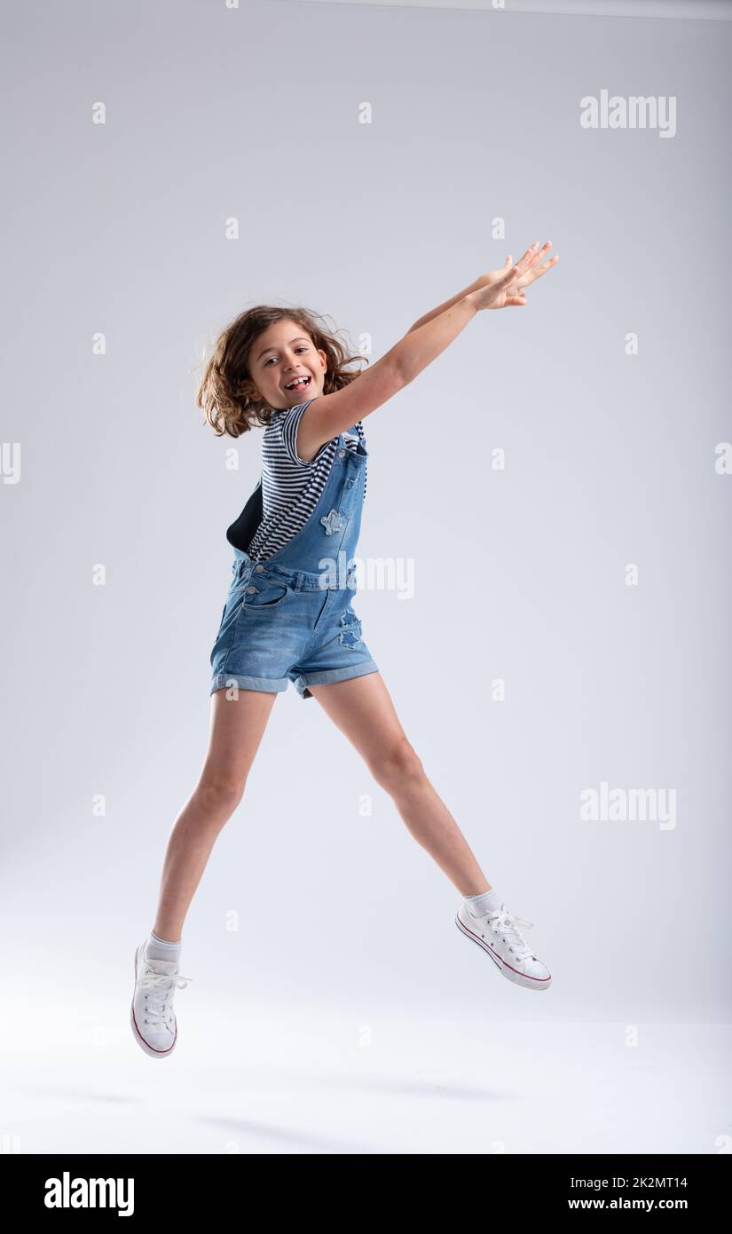 Graceful girl stretching her arms as she jumps Stock Photo