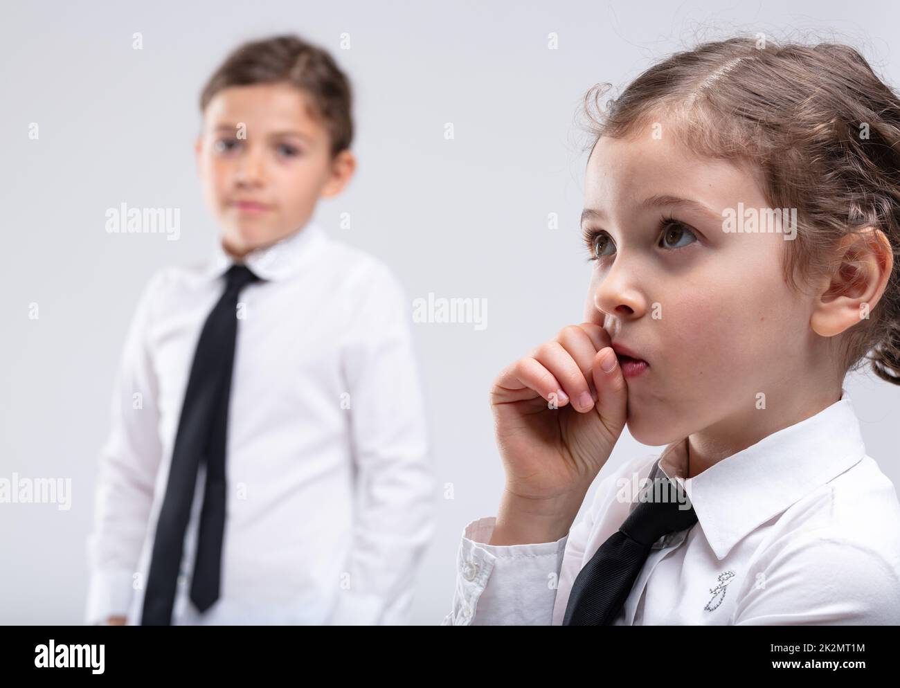 Thoughtful little girl with hand to mouth Stock Photo