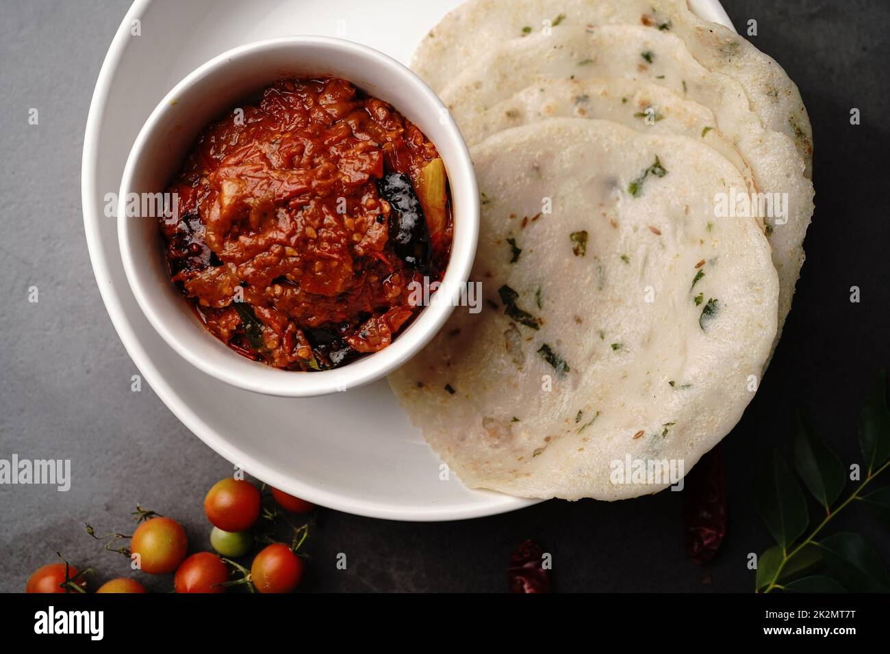 Homemade Tomato pickle Thokku or Chutney served with rice dosa- South Indian breakfast Stock Photo
